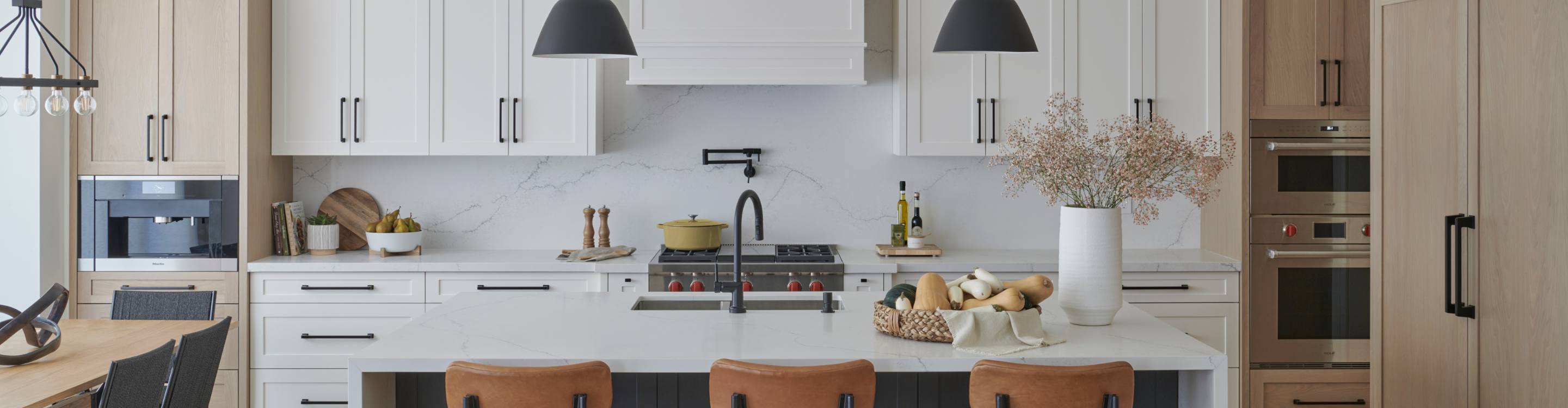 Contemporary kitchen with wood and white cabinets, wood dining table and marble stone waterfall countertop designed by Diana Bastone